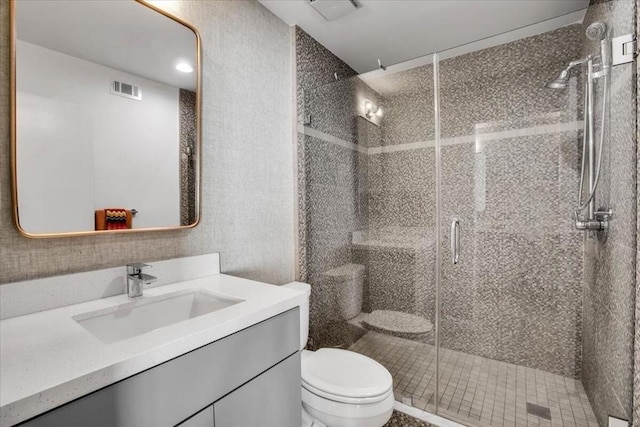 bathroom featuring vanity, toilet, and walk in shower