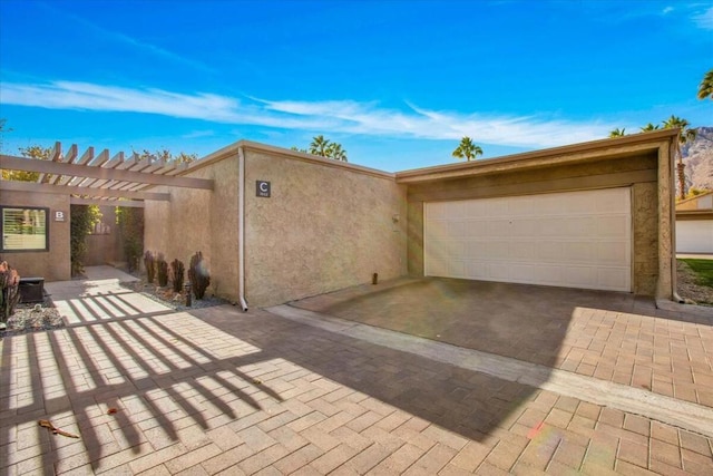 view of front facade featuring a pergola and a garage