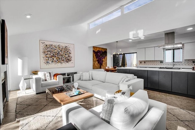 living room featuring high vaulted ceiling and a chandelier