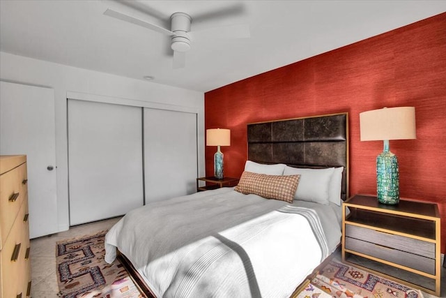 bedroom featuring tile patterned floors, ceiling fan, and a closet