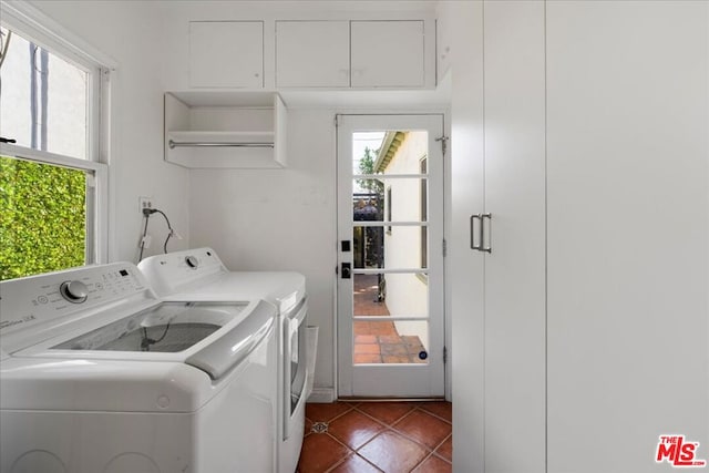 laundry room featuring washing machine and clothes dryer and dark tile patterned flooring