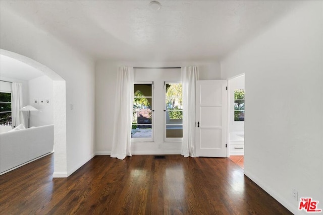 unfurnished room with dark hardwood / wood-style flooring