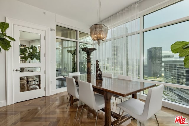 dining area featuring a wall of windows, parquet floors, and an inviting chandelier