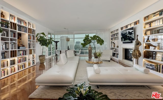 sitting room with built in shelves and parquet flooring