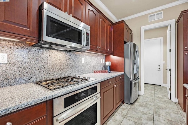 kitchen featuring light stone countertops, light tile patterned floors, tasteful backsplash, crown molding, and appliances with stainless steel finishes