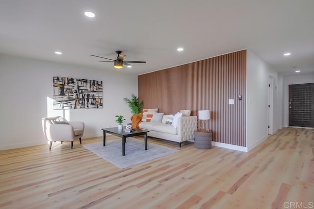 living room with ceiling fan and light hardwood / wood-style flooring