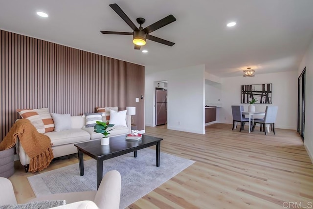 living room featuring light hardwood / wood-style flooring and ceiling fan