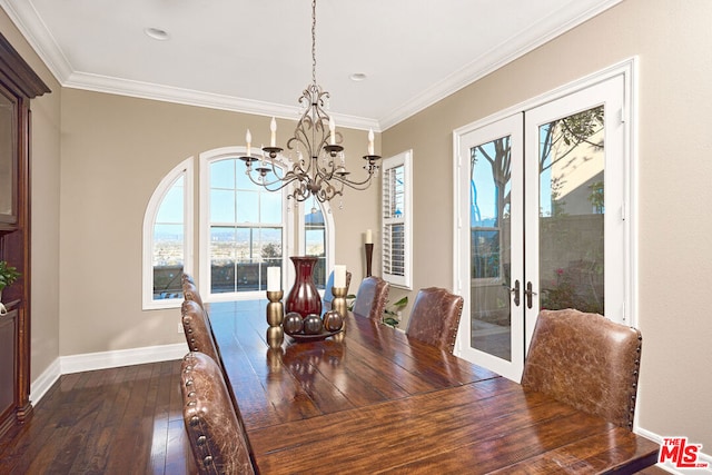 dining area featuring french doors, dark wood-type flooring, a notable chandelier, and ornamental molding