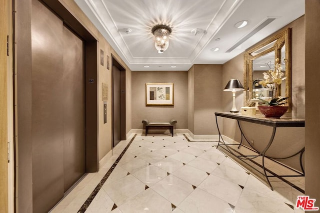 corridor with a tray ceiling and elevator