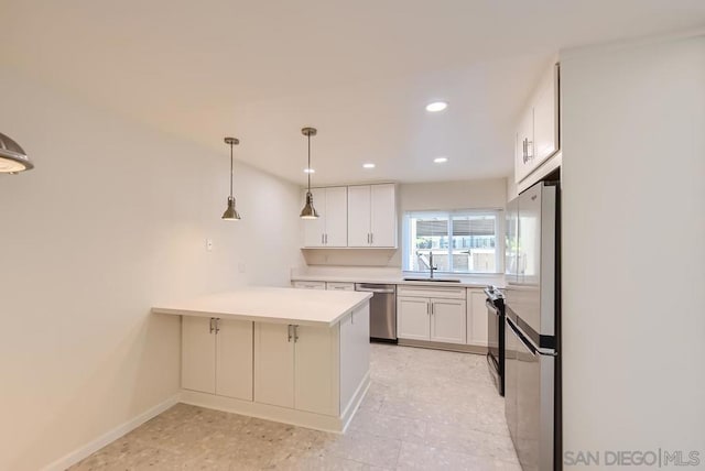 kitchen with kitchen peninsula, appliances with stainless steel finishes, sink, white cabinets, and hanging light fixtures