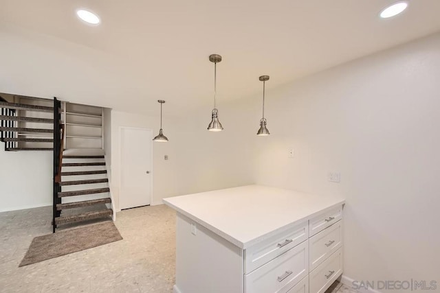 interior space featuring white cabinets, decorative light fixtures, and kitchen peninsula