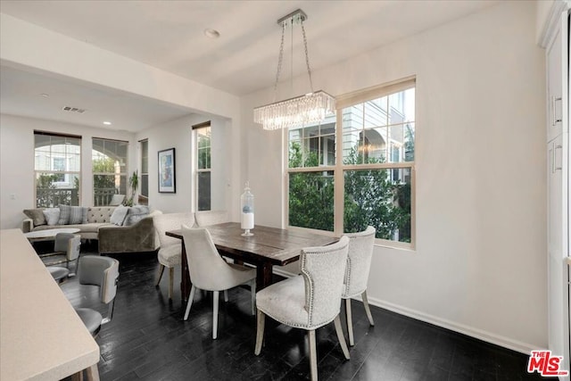 dining area featuring dark hardwood / wood-style floors and an inviting chandelier