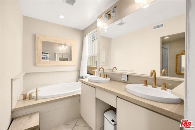 bathroom featuring tile patterned floors, vanity, and tiled tub