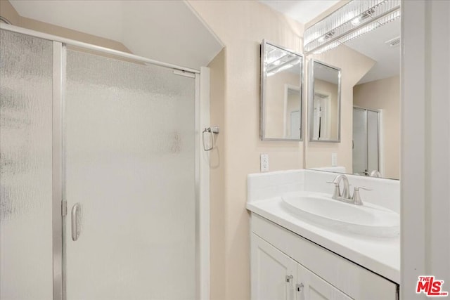 bathroom featuring vanity and an enclosed shower