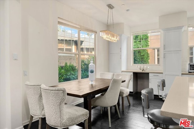 dining area featuring dark hardwood / wood-style flooring and an inviting chandelier