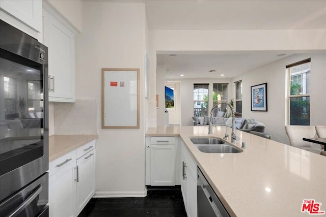 kitchen featuring sink, white cabinets, and black appliances