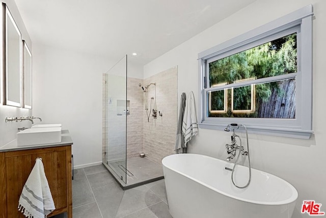 bathroom featuring tile patterned flooring, vanity, and plus walk in shower