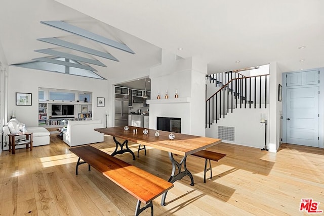 dining space featuring light hardwood / wood-style floors and vaulted ceiling