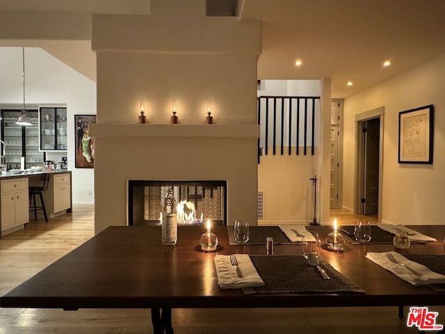 interior space with kitchen peninsula, white cabinets, light hardwood / wood-style flooring, and hanging light fixtures