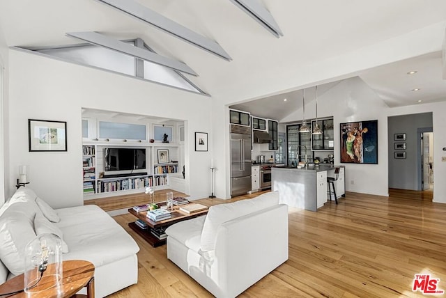 living room with lofted ceiling with beams and light hardwood / wood-style flooring