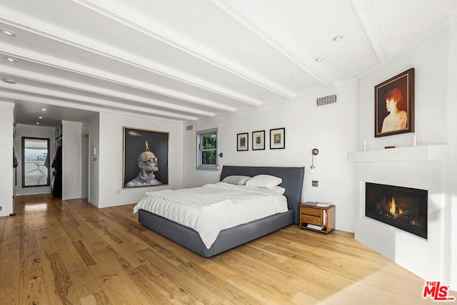 bedroom featuring beam ceiling and hardwood / wood-style flooring