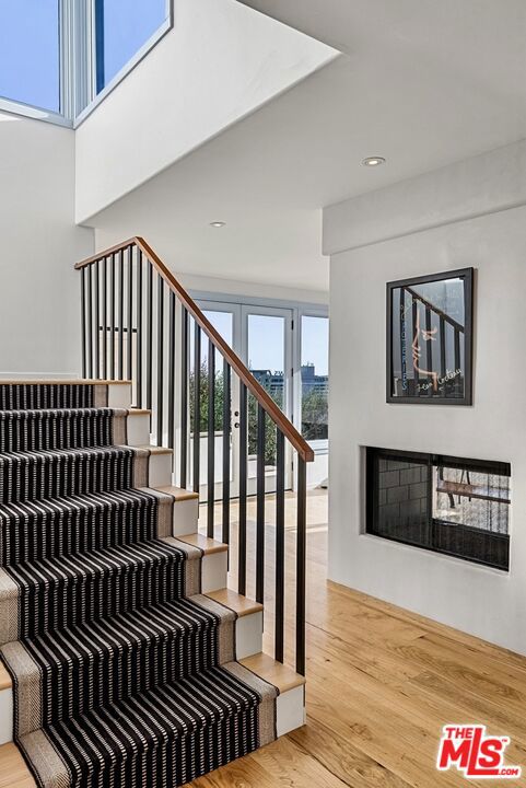 stairway featuring hardwood / wood-style flooring and a wealth of natural light