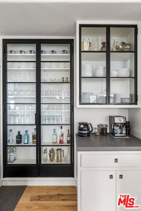 bar featuring white cabinets and hardwood / wood-style floors