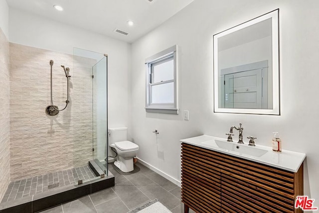 bathroom with tiled shower, vanity, and toilet