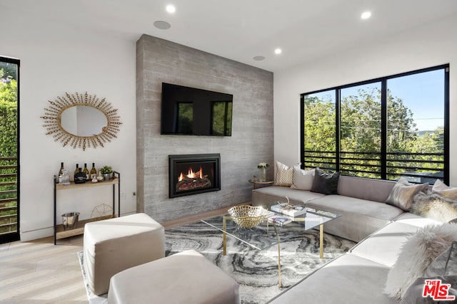 living room with a fireplace and light wood-type flooring