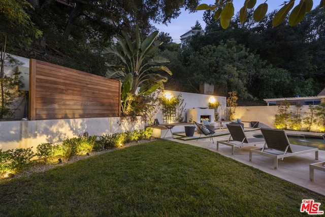 view of yard with a patio and an outdoor fireplace