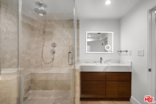 bathroom featuring vanity and a shower with shower door