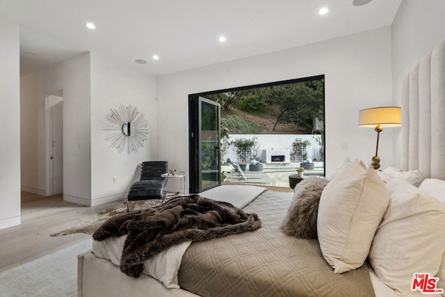 bedroom featuring light wood-type flooring and access to outside