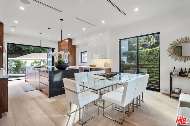 dining space featuring sink and light hardwood / wood-style floors