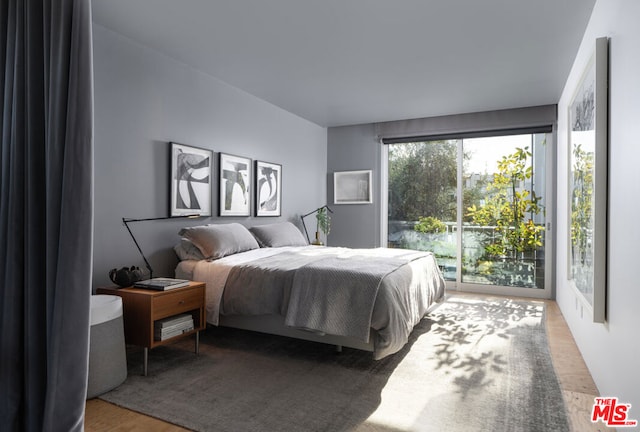 bedroom with access to exterior and wood-type flooring