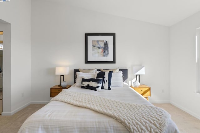 bedroom with lofted ceiling and light carpet