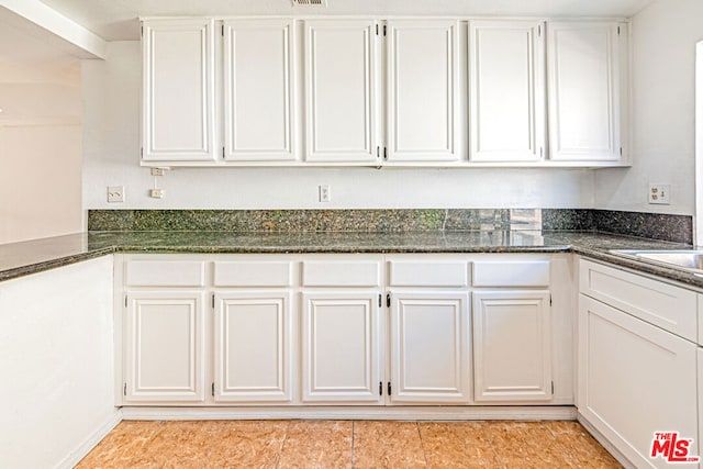 kitchen featuring white cabinets and dark stone counters