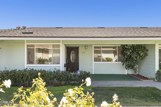 doorway to property featuring a lawn