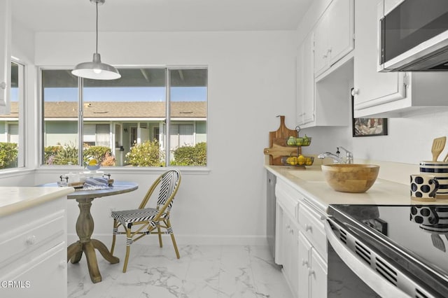 kitchen featuring decorative light fixtures, white cabinetry, plenty of natural light, and sink