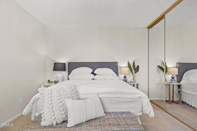 bedroom with carpet flooring, a textured ceiling, and a closet