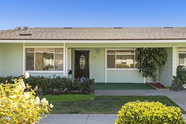 view of exterior entry with a lawn