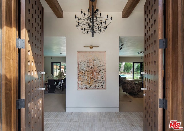 hallway featuring tile patterned flooring, beamed ceiling, and a chandelier