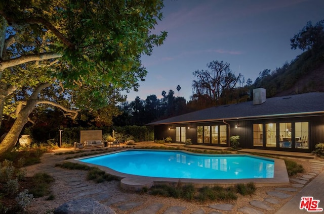 pool at dusk with a patio