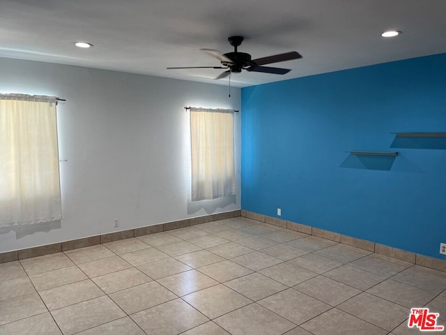 tiled spare room with ceiling fan