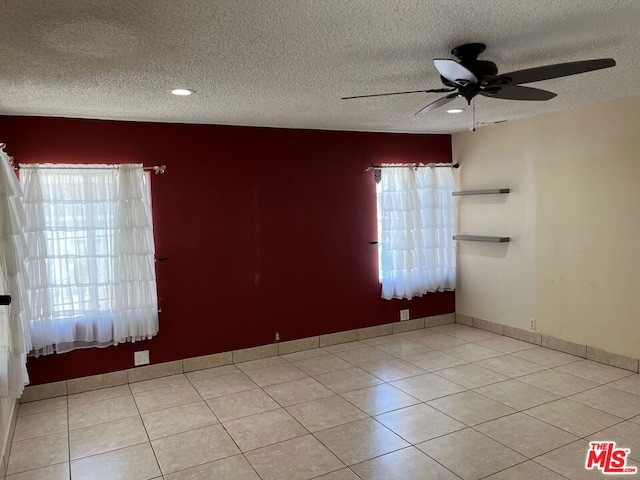 tiled spare room featuring ceiling fan and a textured ceiling