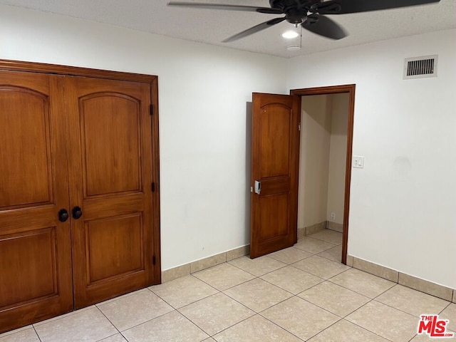 unfurnished bedroom featuring ceiling fan and light tile patterned floors