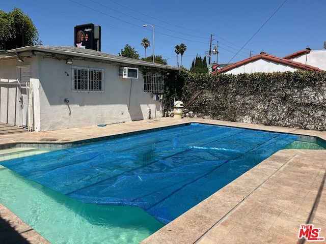 view of swimming pool with a wall mounted AC