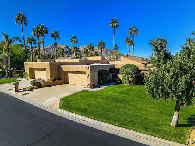 view of front of house featuring a mountain view, a garage, and a front yard