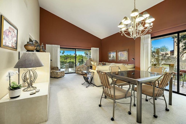 carpeted dining room featuring high vaulted ceiling and an inviting chandelier