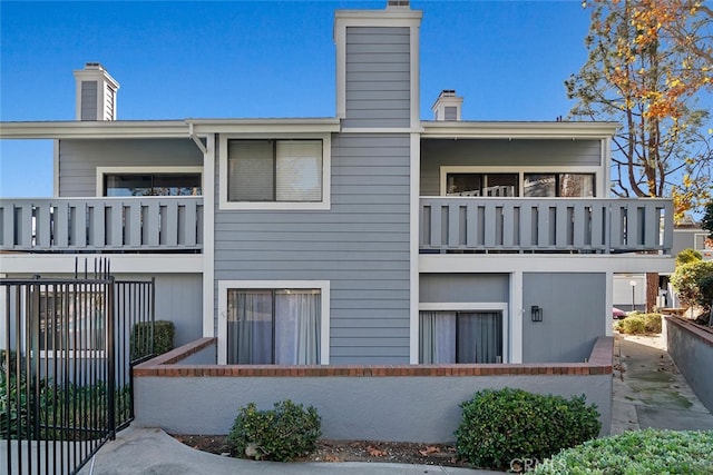 29121 Thousand Oaks Blvd Unit C, Agoura Hills, CA 91301 - back of property with a balcony, a chimney, and a fenced front yard