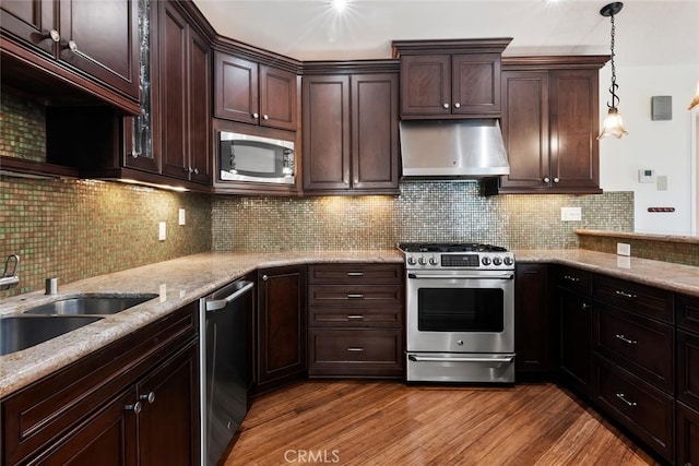 29121 Thousand Oaks Blvd Unit C, Agoura Hills, CA 91301 - kitchen with appliances with stainless steel finishes, exhaust hood, dark brown cabinetry, and light stone counters